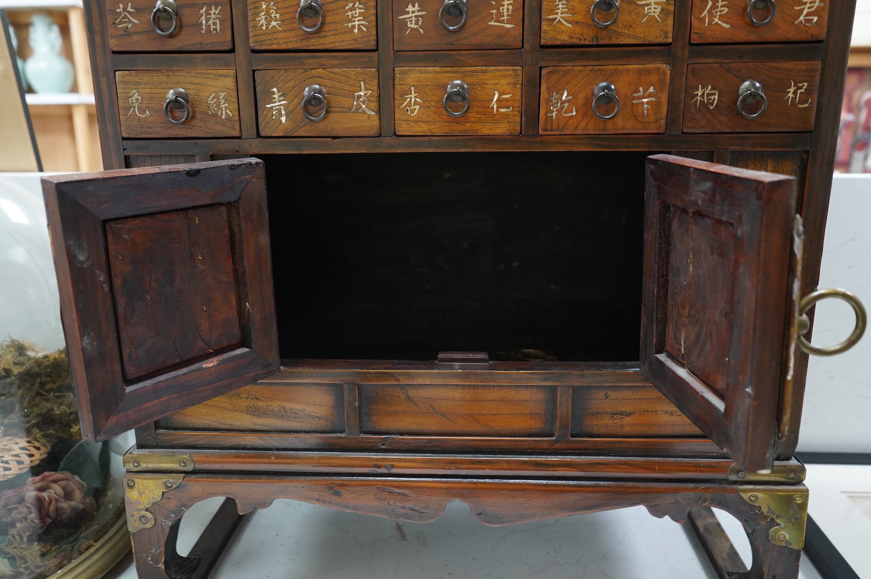 A Korean brass mounted chest with fitted drawers, decorated with calligraphy, 64cm high
